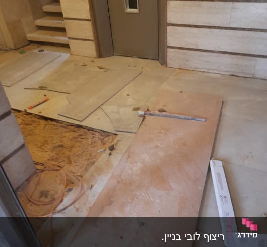 חומרים וכלים לשיפוץ ליד דלת, כולל לוחות וחוטים